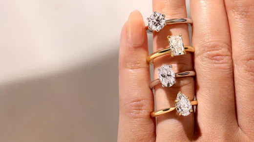 A hand showcasing four different diamond engagement ring styles