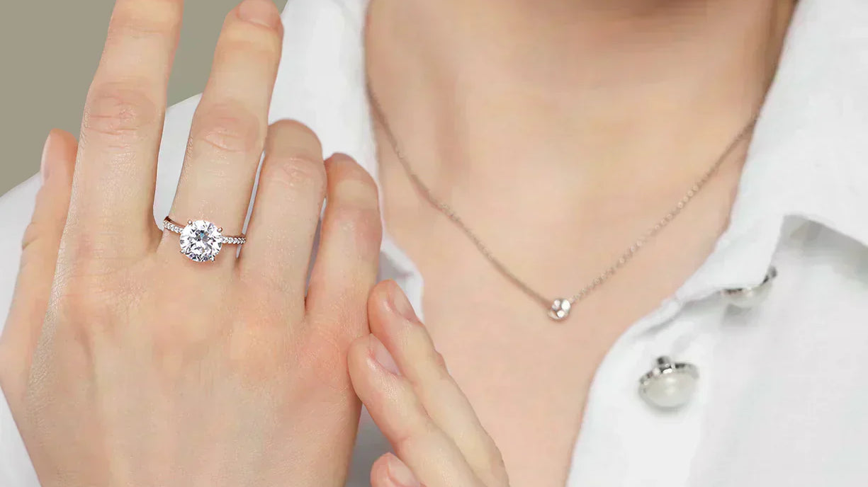A close-up of a woman's hand showcasing a solitaire diamond ring on her ring finger
