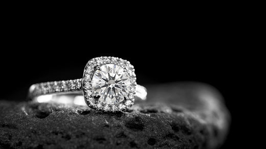 A halo engagement ring with a round-cut diamond as the centerpiece, encircled by a halo of smaller diamonds