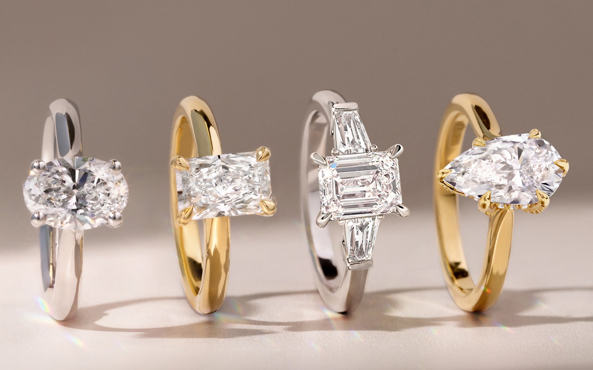 Four lab grown diamond engagement rings in gold on a neutral background. Lucenjuri