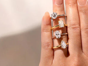 A hand showcasing four different diamond engagement ring styles