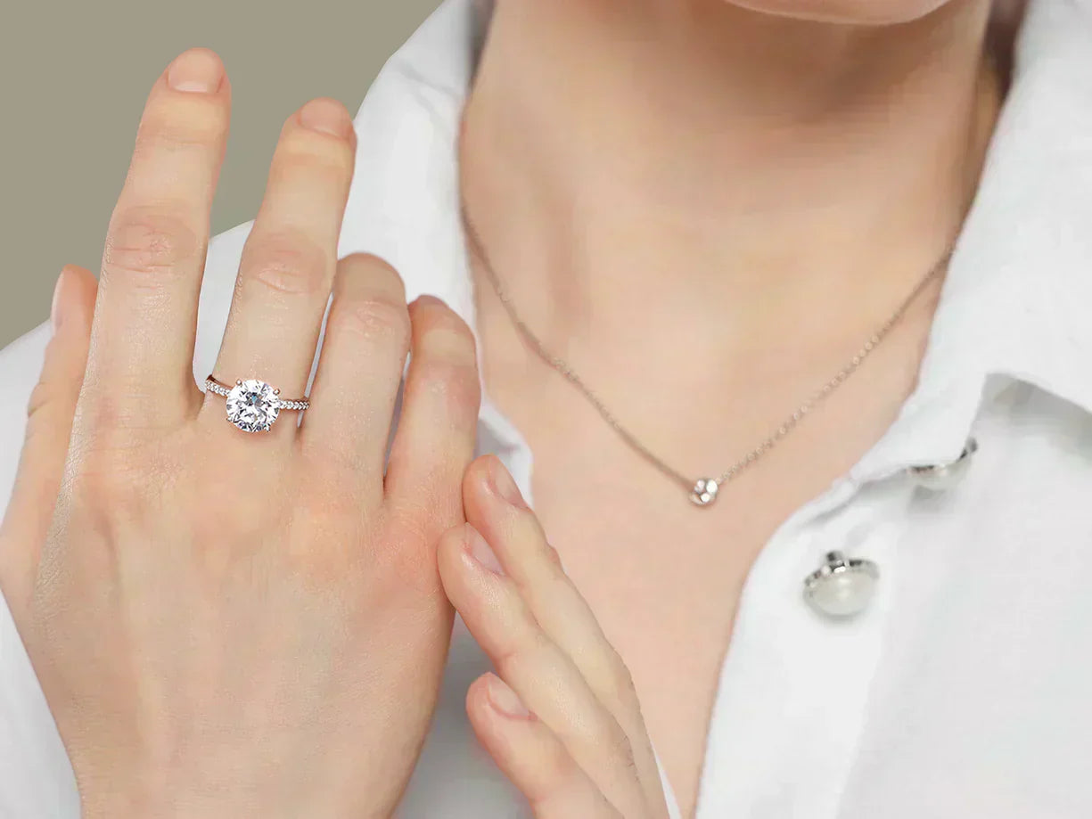 A close-up of a woman's hand showcasing a solitaire diamond ring on her ring finger