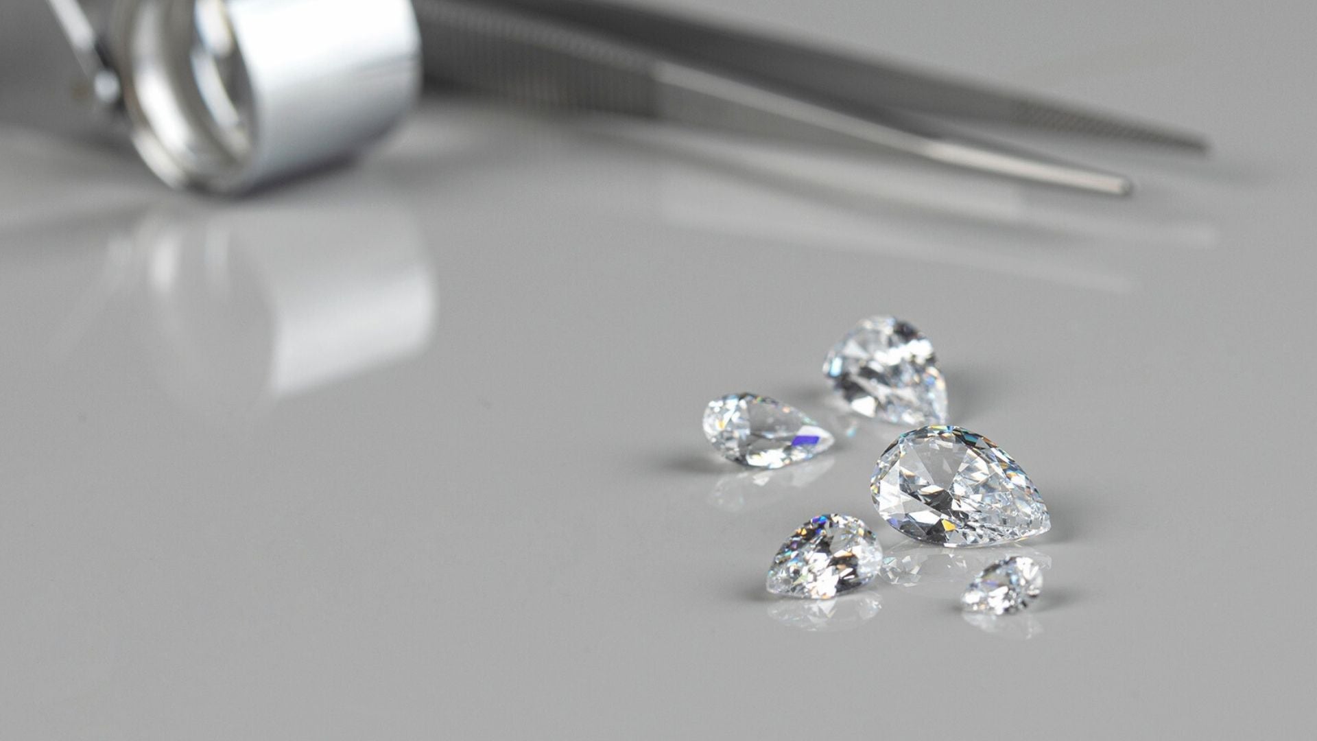 A close-up of several loose lab-grown diamonds, demonstrating their brilliance and clarity