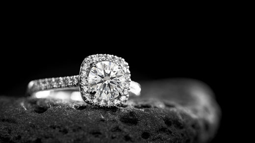 A halo engagement ring with a round-cut diamond as the centerpiece, encircled by a halo of smaller diamonds