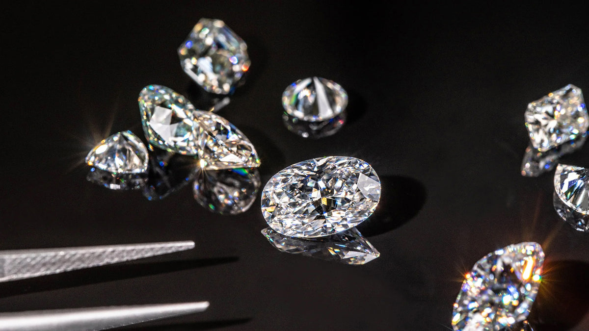 Lab diamonds on a reflective surface with a dark background