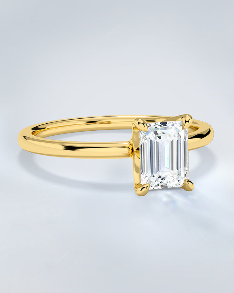 Gold engagement ring with a large lab diamond on a light gray background