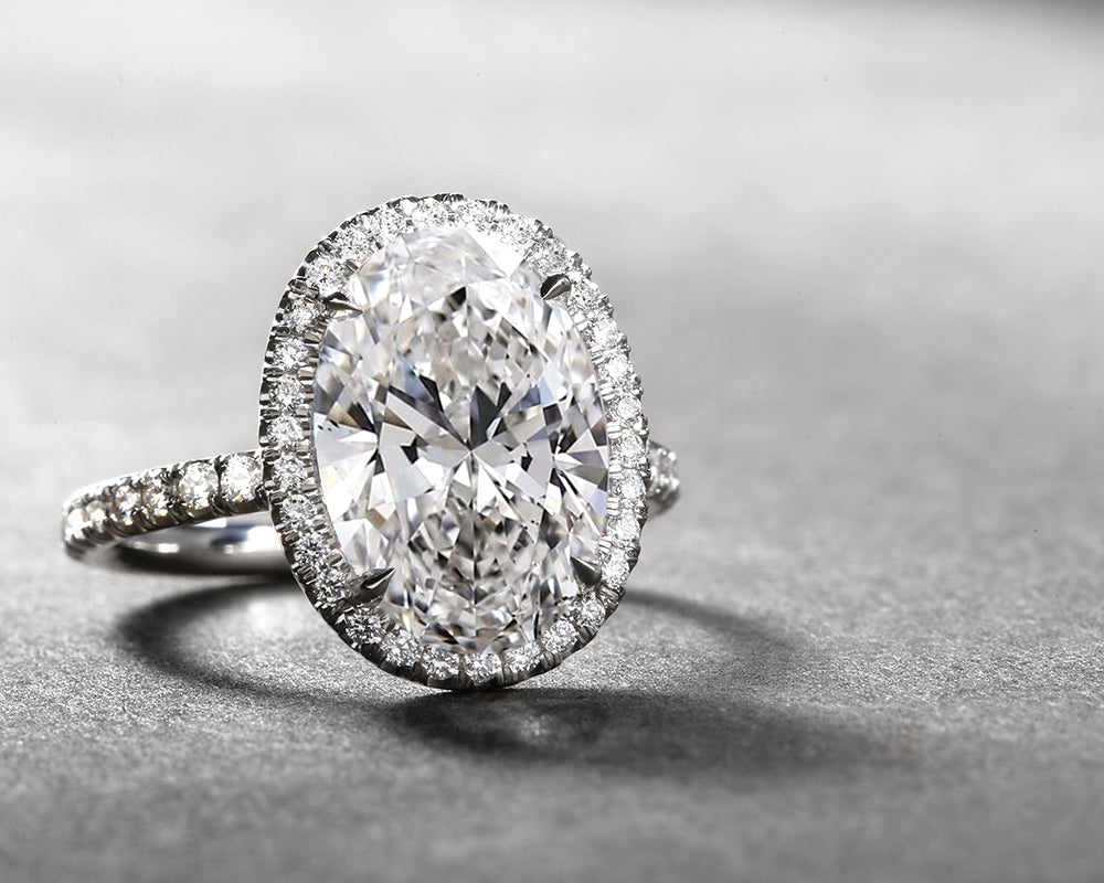 Oval lab grown diamond engagement ring on a grey background
