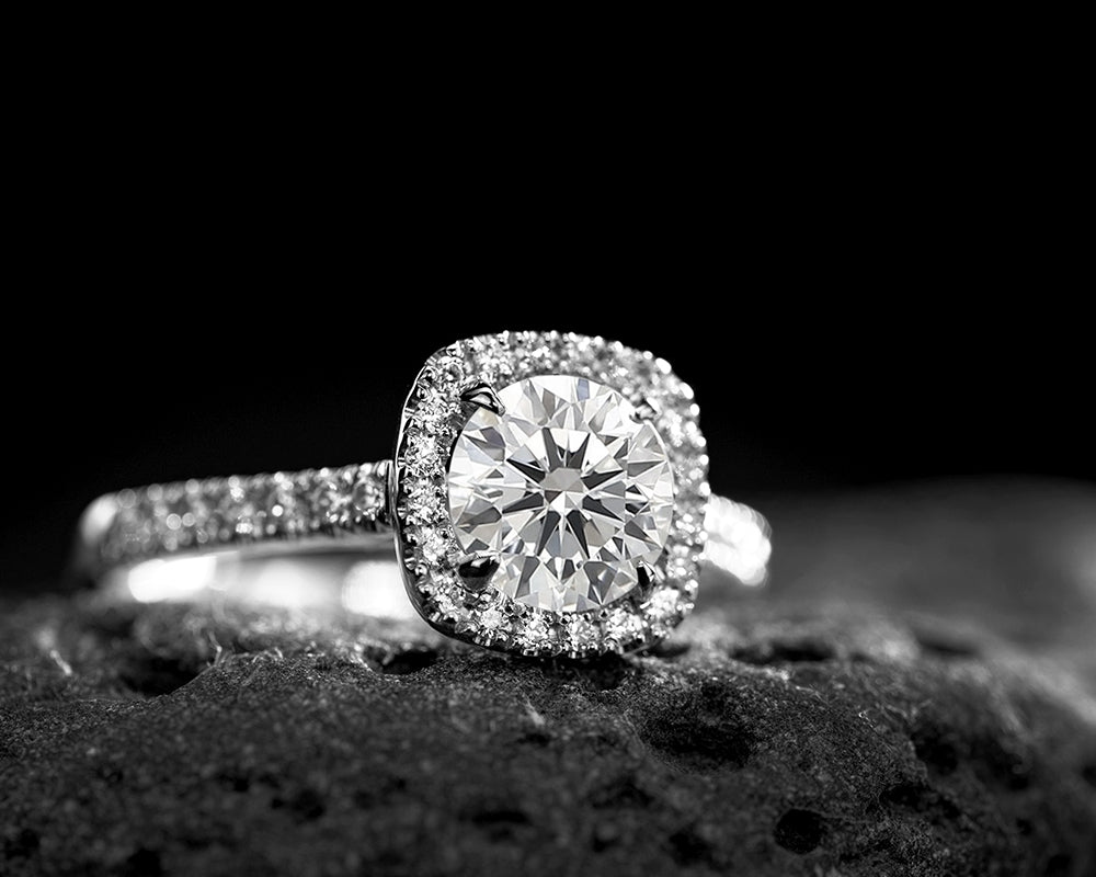 Round lab grown diamond engagement ring on a black background