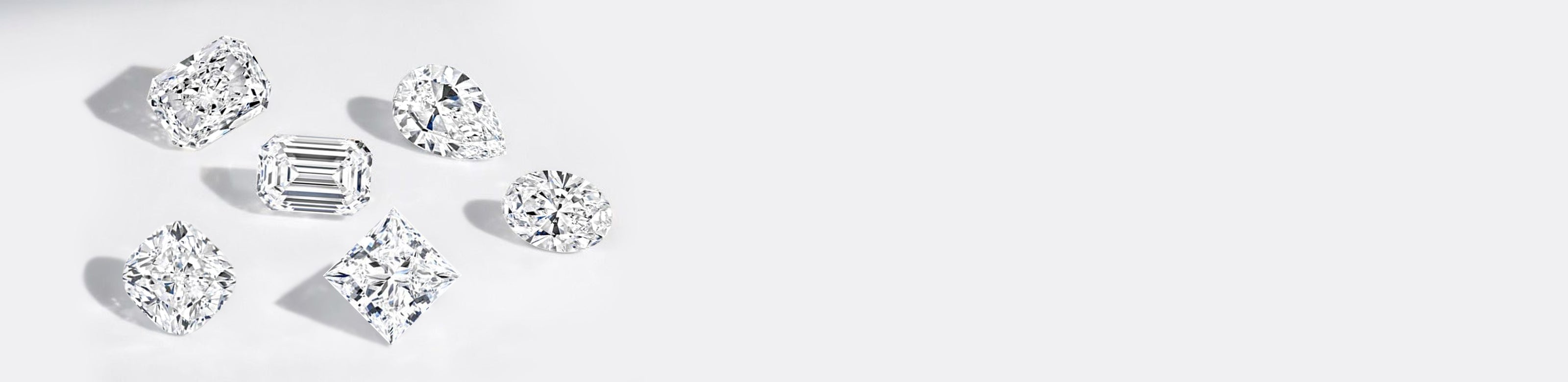 Collection of various cut lab diamonds on a light gray background