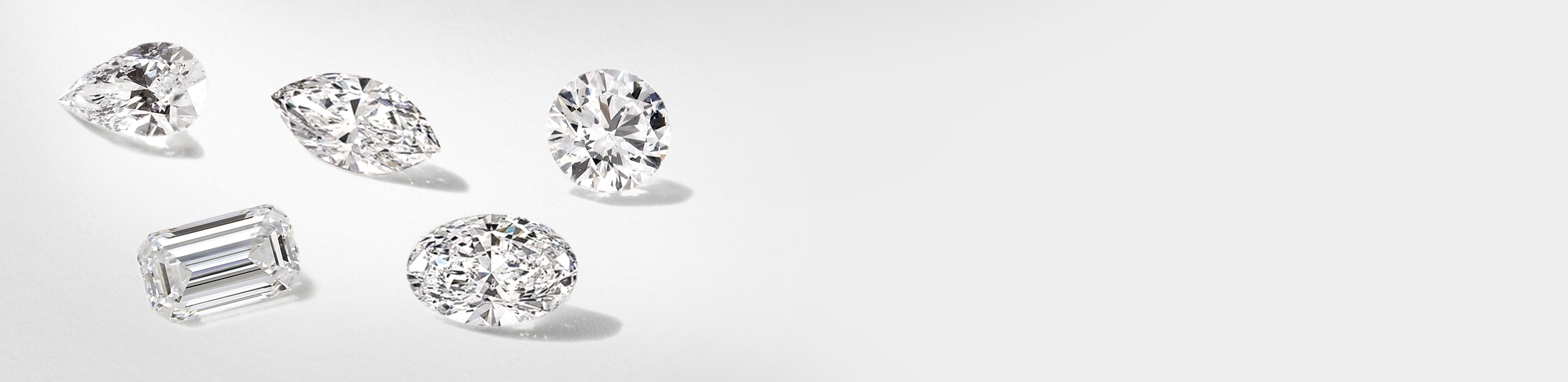 Collection of various lab grown diamonds on a light gray background