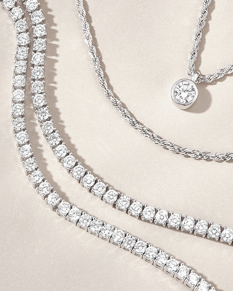 3 Beautiful lab grown diamond necklaces on a beige background