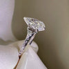 Side profile of a pear-cut diamond engagement ring featuring a vintage-style filigree band with milgrain edges in polished white gold.