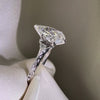 Side profile of a pear-cut diamond engagement ring featuring a vintage-style filigree band with milgrain edges in polished white gold.
