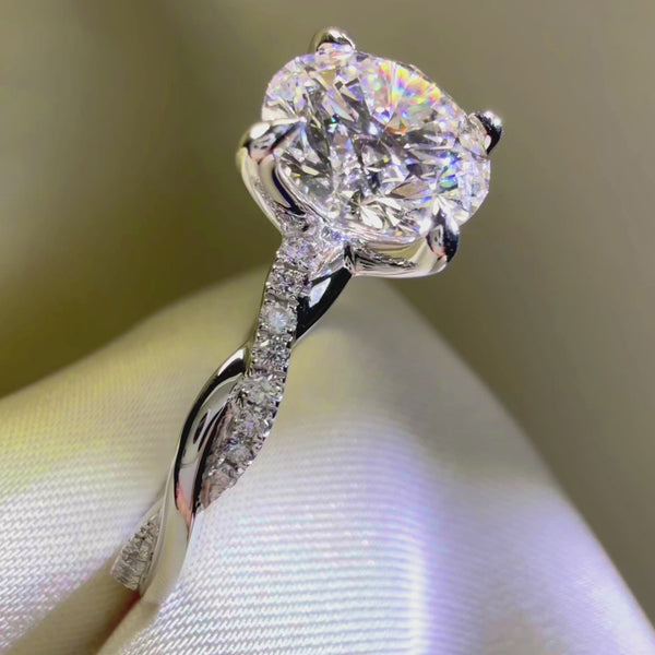 Round cut diamond engagement ring, twisted pavé diamond band, white gold engagement ring, luxury jewelry macro photography.