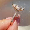 Side profile of a pear-cut diamond engagement ring featuring a hidden halo, a four-prong yellow gold setting, and a sparkling pavé-set diamond band.