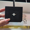 Oval-cut lab diamond engagement ring with a pavé-set twisted infinity band, displayed in a black velvet jewelry insert with an IGI certification report in the background.