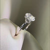 Side profile of an oval-cut diamond engagement ring featuring a hidden halo and a diamond-encrusted basket on a polished white gold band.